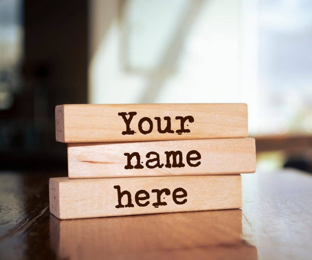 'Your name here' etched onto three wooden blocks on an unfocused background