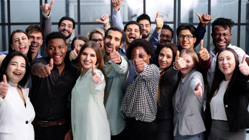 A group of people smiling and giving the 'thumbs up' sign